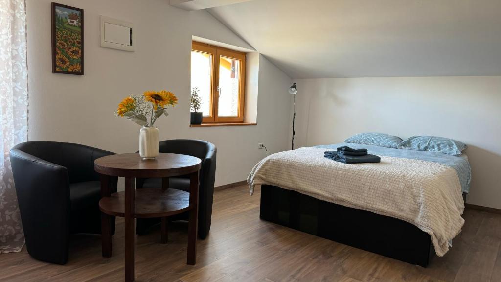 Schlafzimmer mit einem Bett, einem Tisch und Stühlen in der Unterkunft GuestHouse Flora in Koper