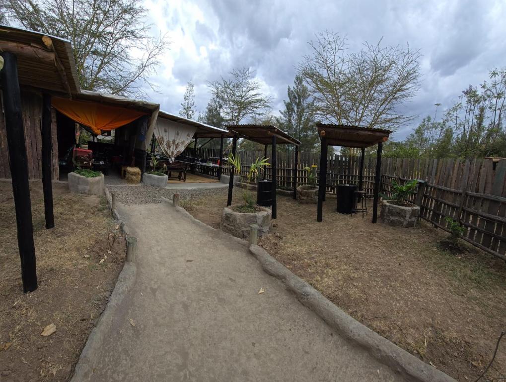 a garden with a pavilion and a fence at Lillypond Camp in Elmenteita