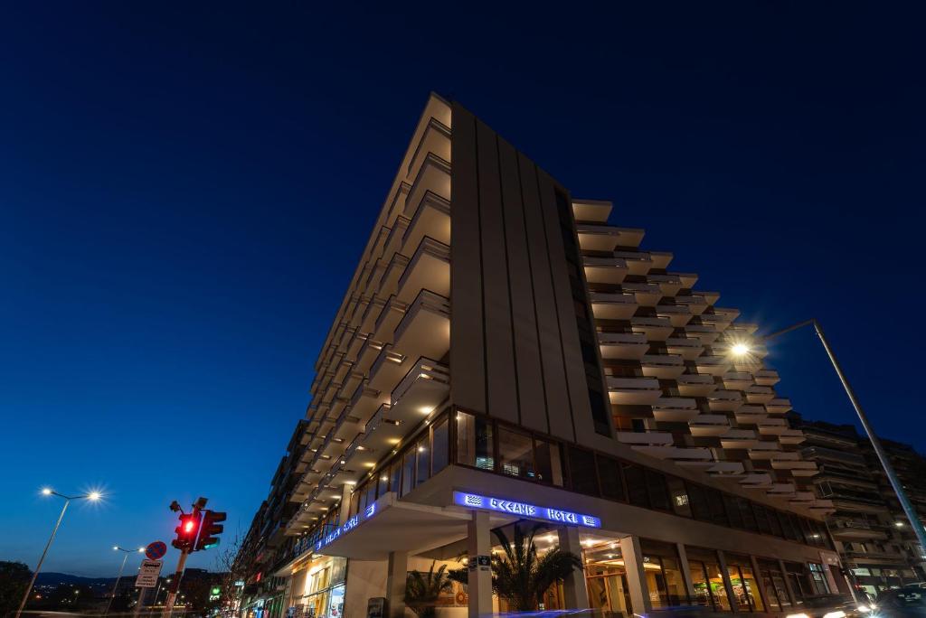 a tall building on a city street at night at Oceanis Hotel in Kavála
