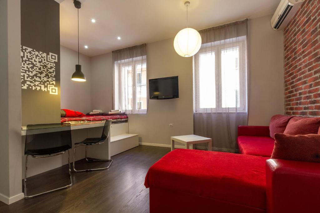 a living room with a red couch and a desk at Apartments Aspalathos in Split
