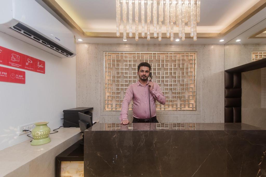 a man standing behind a counter in a room at OYO Flagship Hotel Park Palace in Mumbai