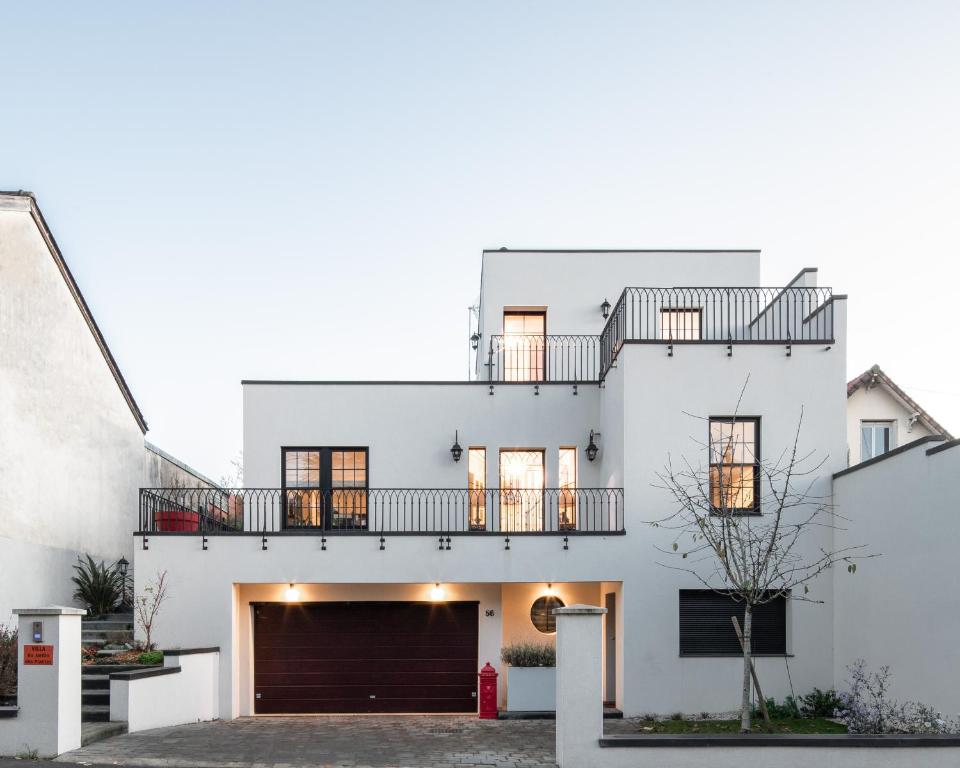 une maison blanche avec un garage dans l'établissement Villa du jardin des plantes 56 Rue Prémartine, au Mans