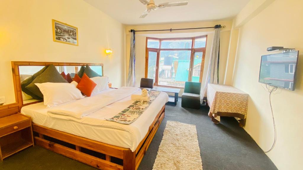- une chambre avec un grand lit et une télévision dans l'établissement Hotel Hamta View Manali !! Top Rated & Most Awarded Property in Manali !!, à Manali