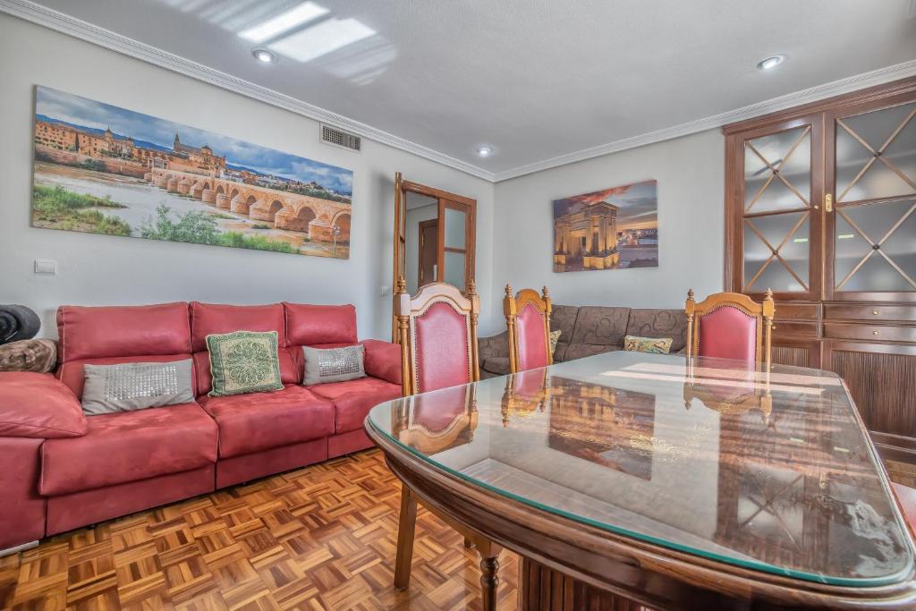 a living room with a red couch and a glass table at Apartamento Esmeralda & Centro & Parking in Córdoba