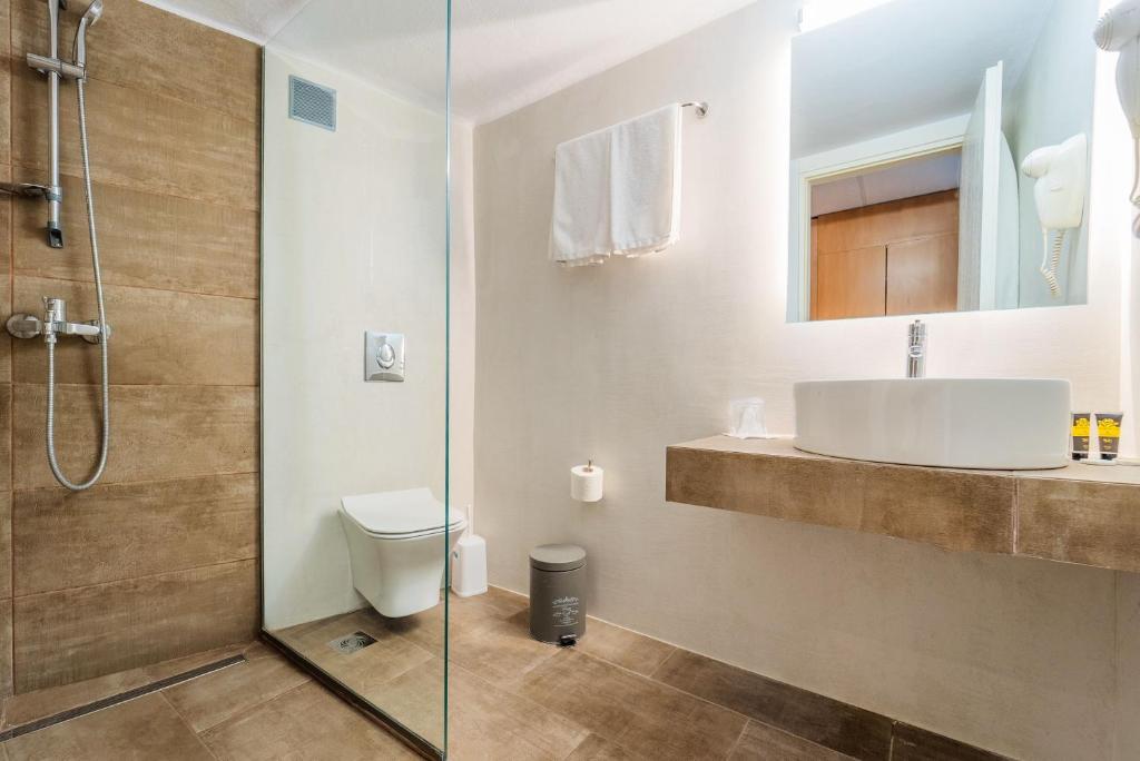 a bathroom with a shower and a toilet and a sink at Oceanis Hotel in Kavála