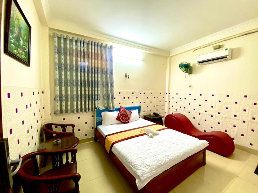 1 dormitorio con 1 cama y 1 silla en Ngoc dung MoTel en Vung Tau