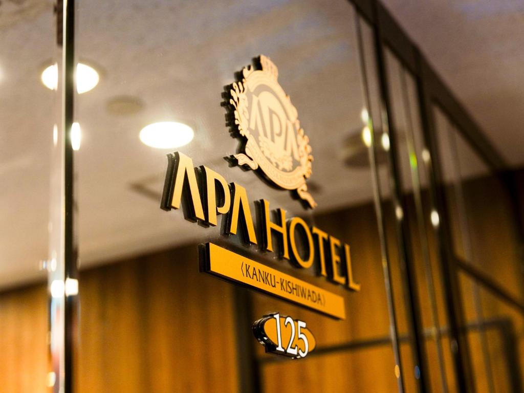 APA Hotel Kanku-Kishiwada في Kishiwada: لافته لفندق على جانب مبنى