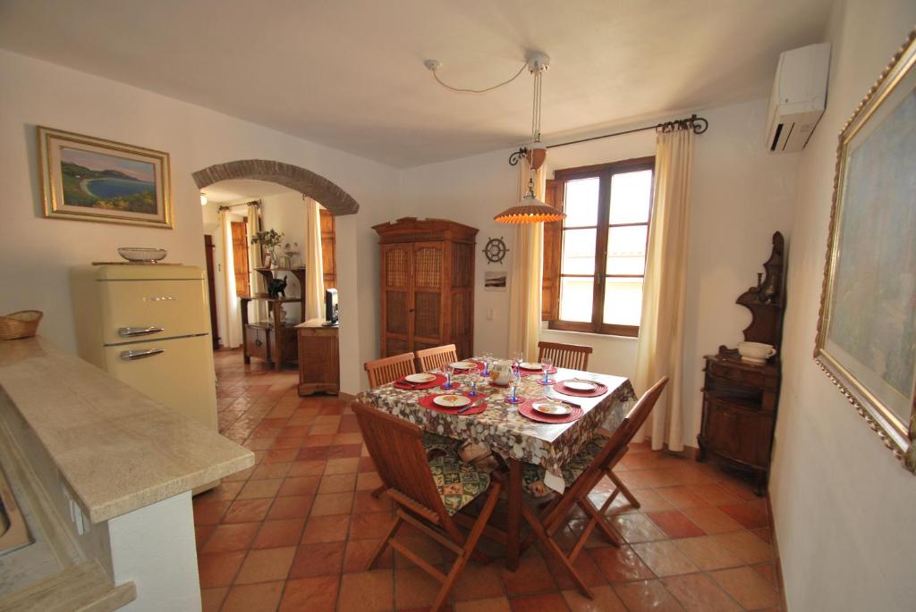 a dining room with a table with dishes on it at Appartamento VIAROMA58 - Vicinissimo al mare con clima e posto auto in Marina di Campo
