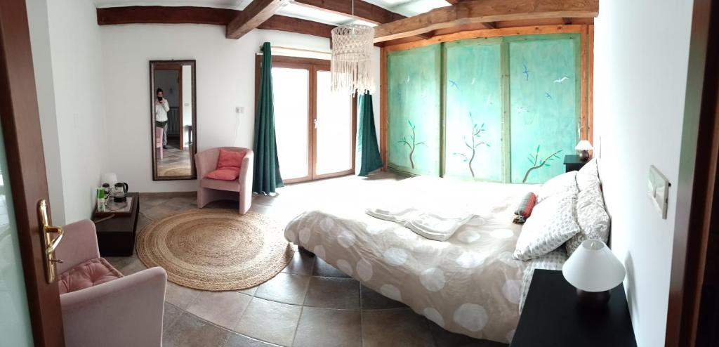 a bedroom with a bed and a large window at Amrita Rosa in Castellamonte