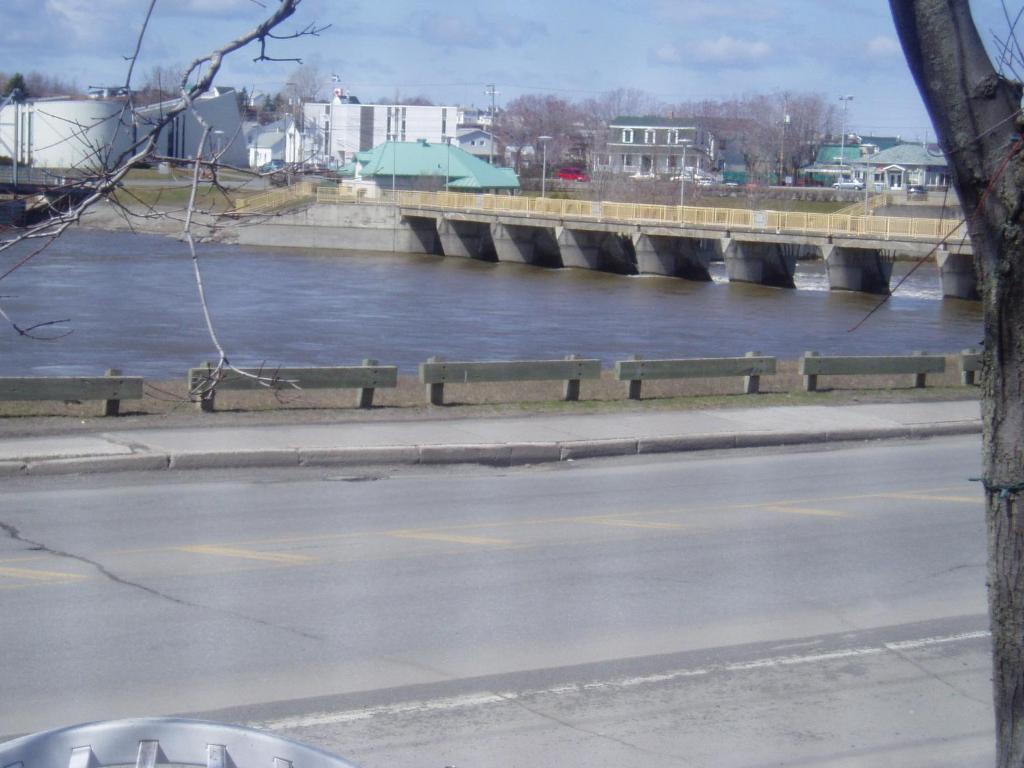 a bridge over a river next to a road at gite des iles in Matane