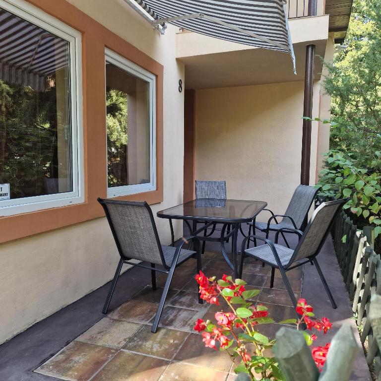 a patio with a table and chairs on a house at Ośrodek Wypoczynkowy Puszczyk Domek Akacjowy- Apartament -Willa in Sieraków