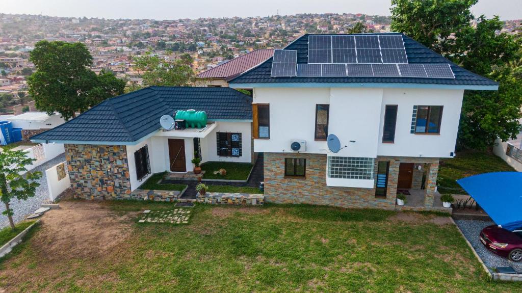a house with solar panels on the roof at Inviting 3-Bed House in Awoshie Accra in Kwashieman