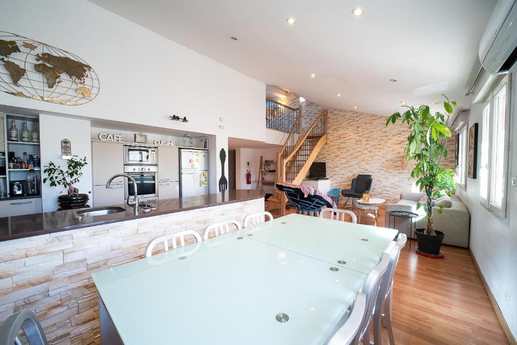 a kitchen and living room with a table and chairs at Mialie Duplex familial classé 3 étoiles in Le Boulou