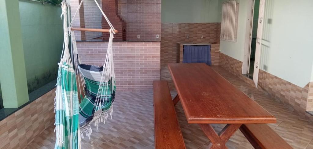um banco de madeira e uma rede de descanso num quarto em Casa praia de Guriri temporada em Guriri