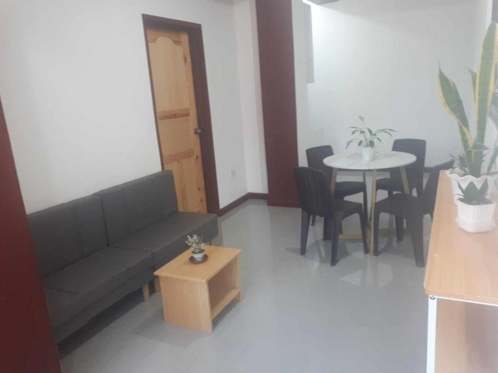 een woonkamer met een bank en een tafel bij 2Ms in Baguio