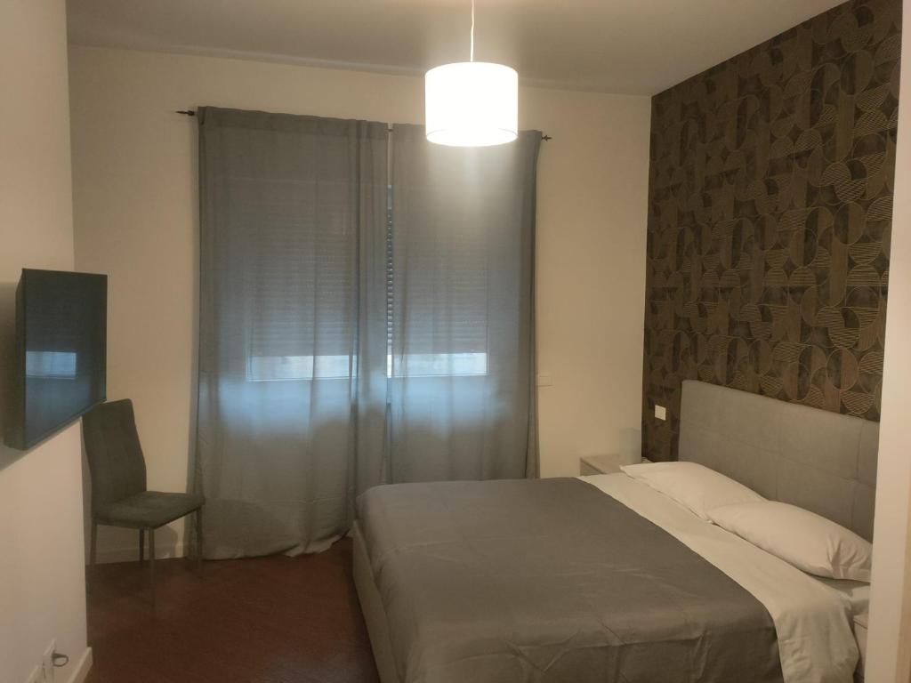 um quarto com uma cama, uma cadeira e uma janela em Il covo dei Briganti em Roma