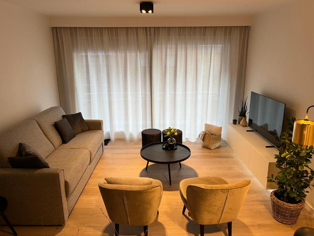 a living room with a couch and a table at Studio-be in Nieuwpoort