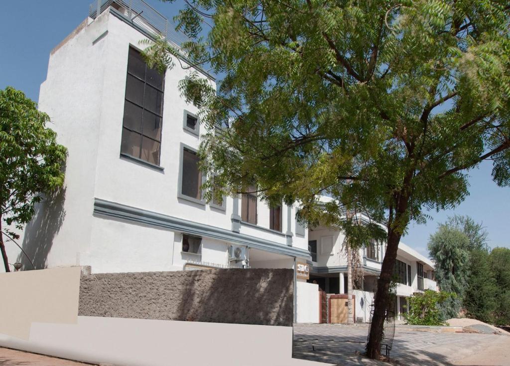 a white building with a tree in front of it at S B Excellency in Jodhpur