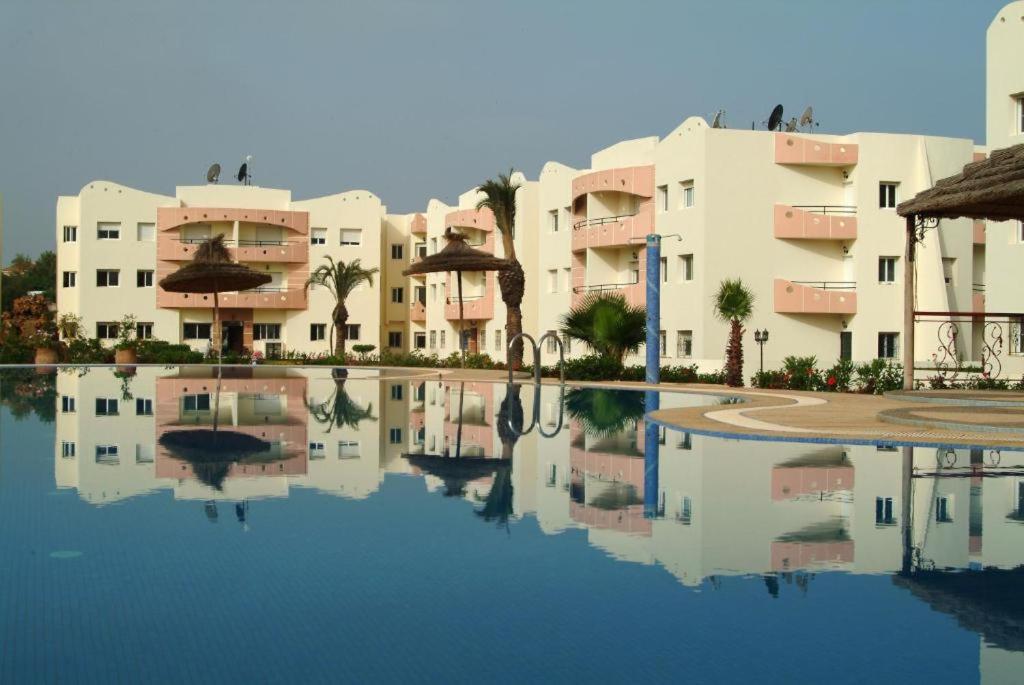 un reflejo de edificios en un charco de agua en Mohammedia Plage et piscines en Mohammedia