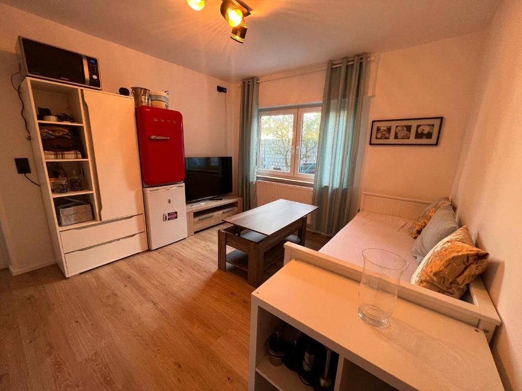 ein kleines Wohnzimmer mit einem Sofa und einem Kühlschrank in der Unterkunft Ferienzimmer Schlüter in Neulußheim