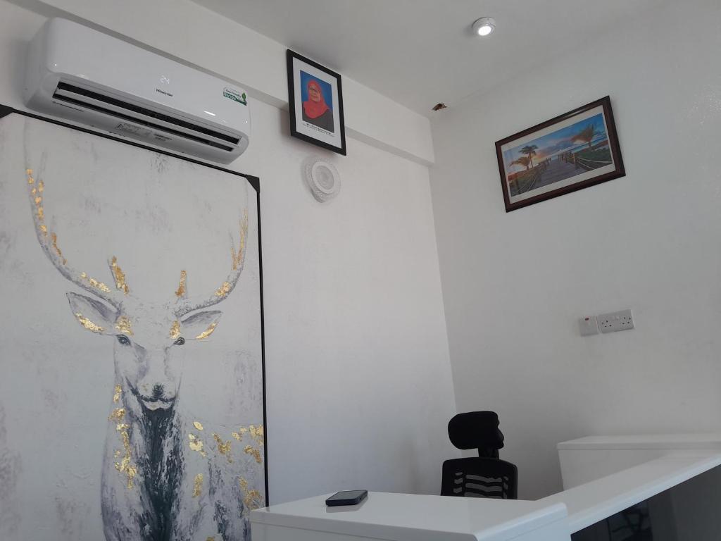 een muur met een schilderij van een hert erop bij DODOMA WHITE HOTEL in Dodoma