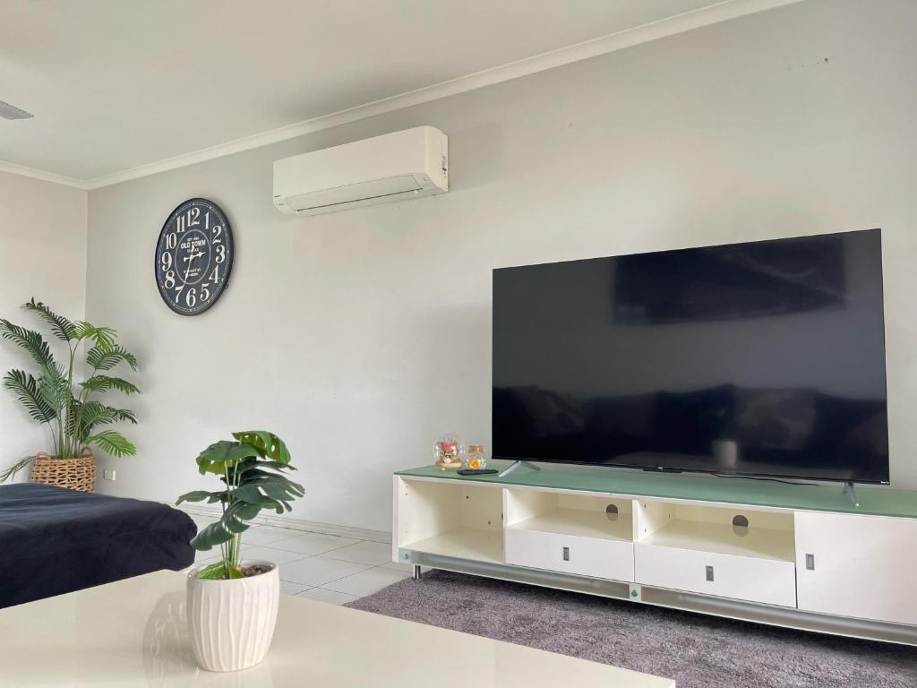 sala de estar con TV de pantalla plana grande en Chill at Runaway Bay, en Gold Coast