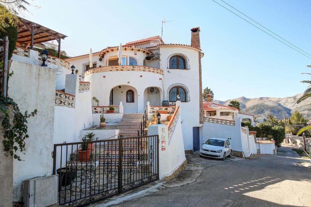 a white house with a car parked in front of it at Casa Miranda in Orba