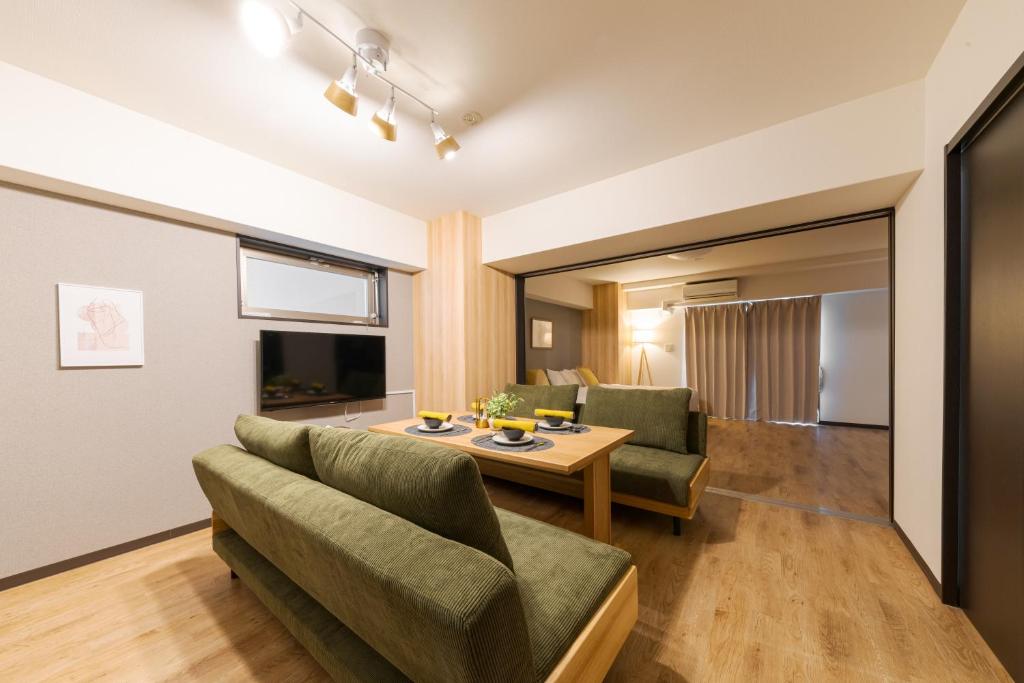 a living room with a couch and a table at TAKUTO STAY SAKAISUJI-HOMMACHI in Osaka