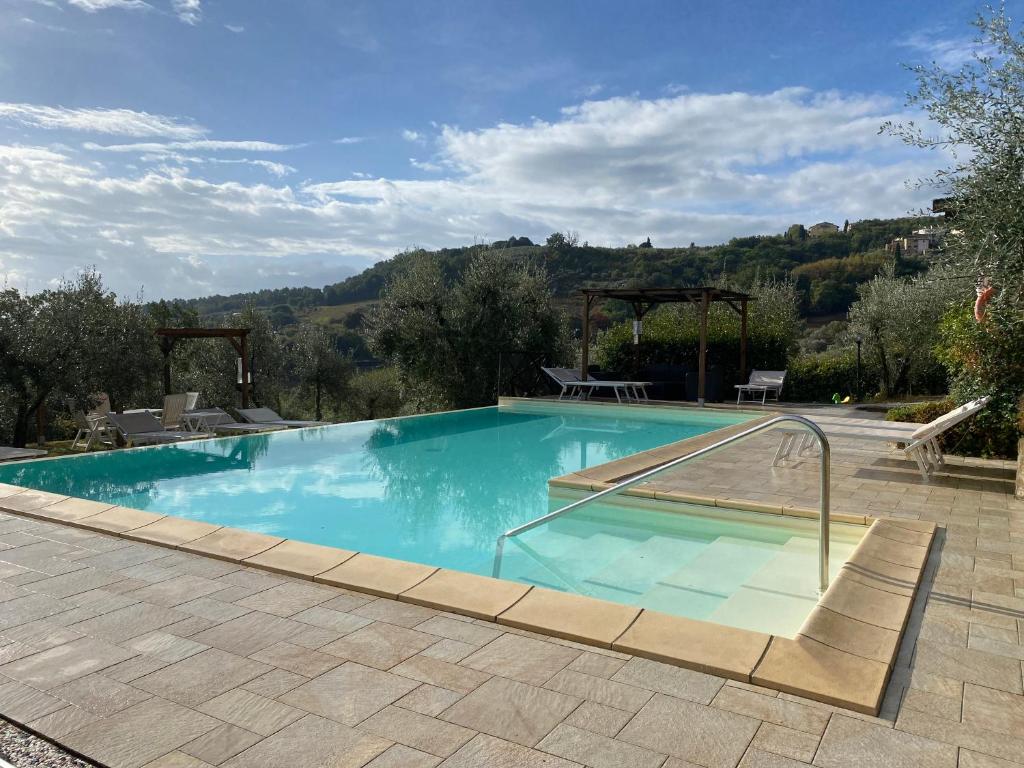 een groot zwembad met helderblauw water bij Villa Le Ripe Apartments in Gambassi Terme