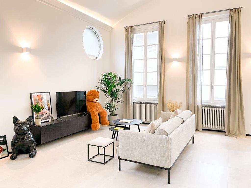 a living room with a teddy bear sitting on the tv at Diaz Novantuno - Luxury Apartments Como City Center in Como