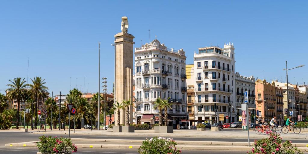 uma rua da cidade com edifícios e uma cruz numa torre em HABITACIÓN CÉNTRICA EN ACOGEDORA CASA em Valência