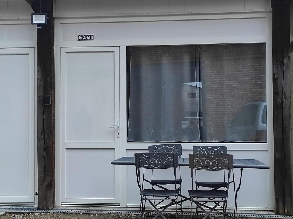 a table and two chairs in front of a garage at maison luxe cléo aeroport tillé 4 a 5 personnes in Tillé