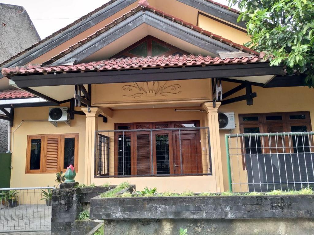 uma pequena casa amarela com um telhado vermelho em Joyful Home 2 em Yogyakarta