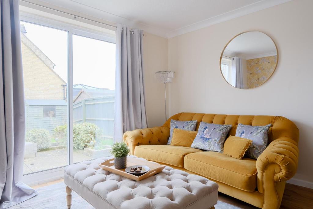 a living room with a couch and a large window at Bibury House a lovely 2 bed house sleeps 4 in Witney