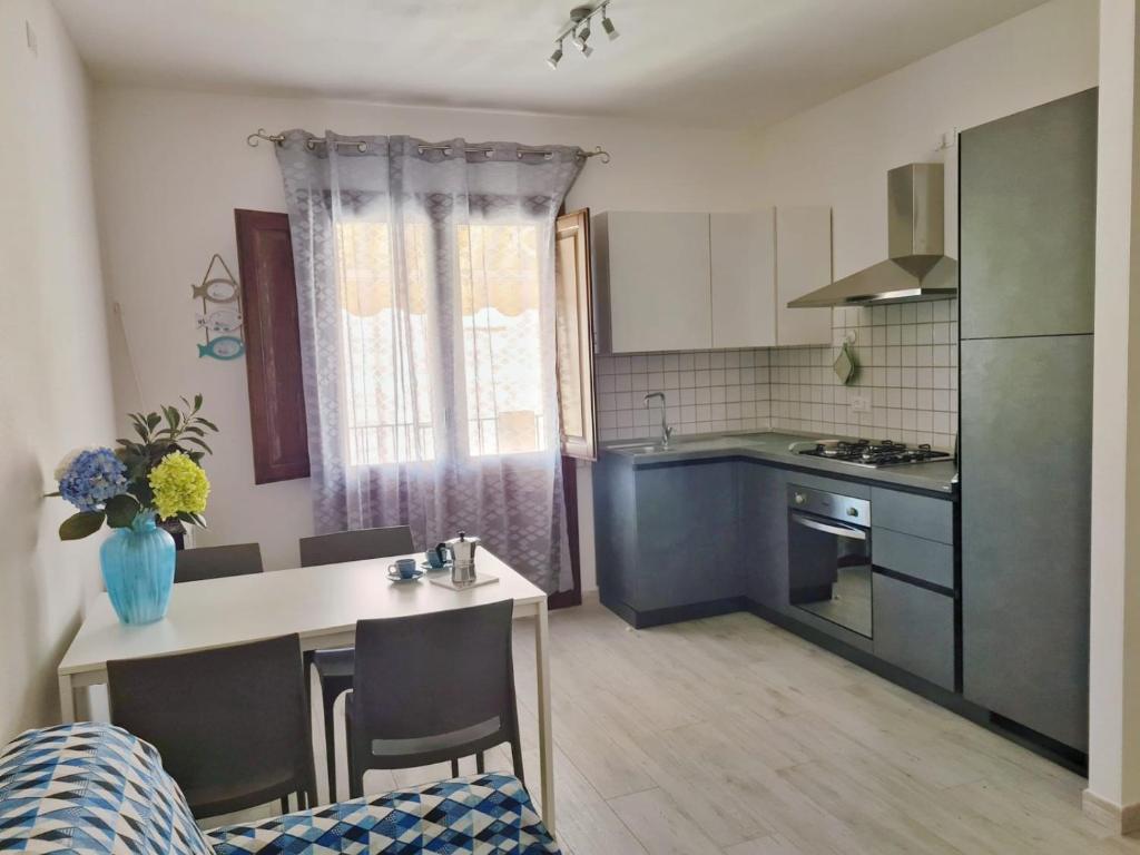 eine kleine Küche mit einem Tisch und einer Arbeitsplatte in der Unterkunft Ma.Vi Casa Vacanze in Teulada