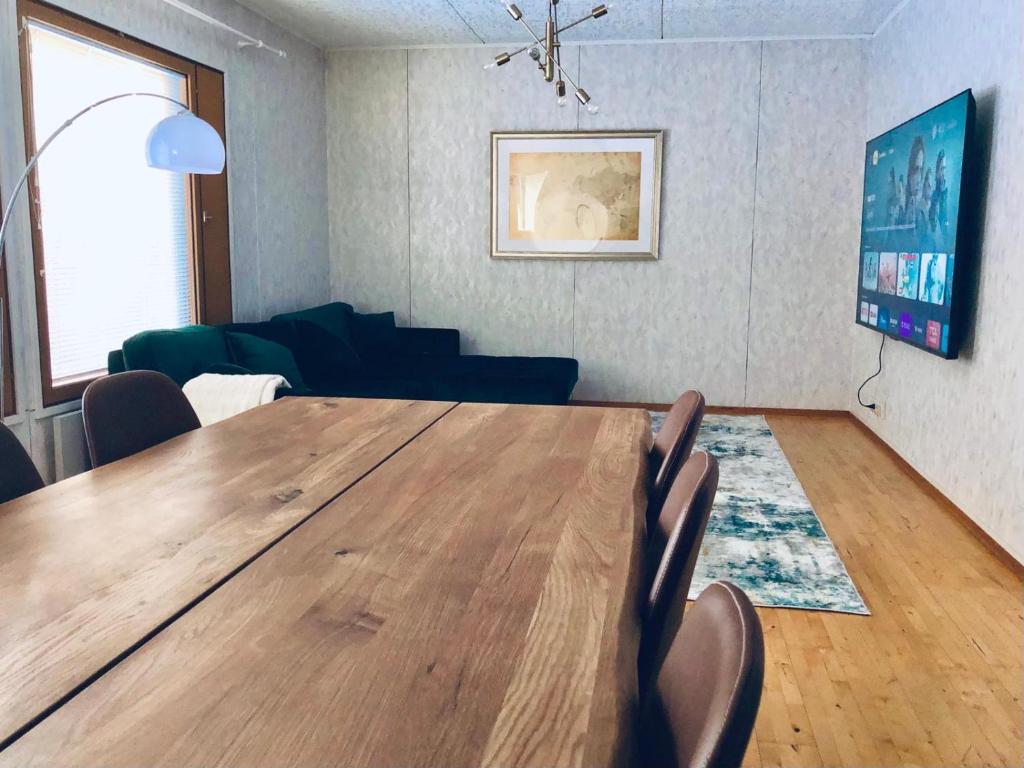 ein Esszimmer mit einem Holztisch und Stühlen in der Unterkunft Detached house Mämmensalmi in Äänekoski