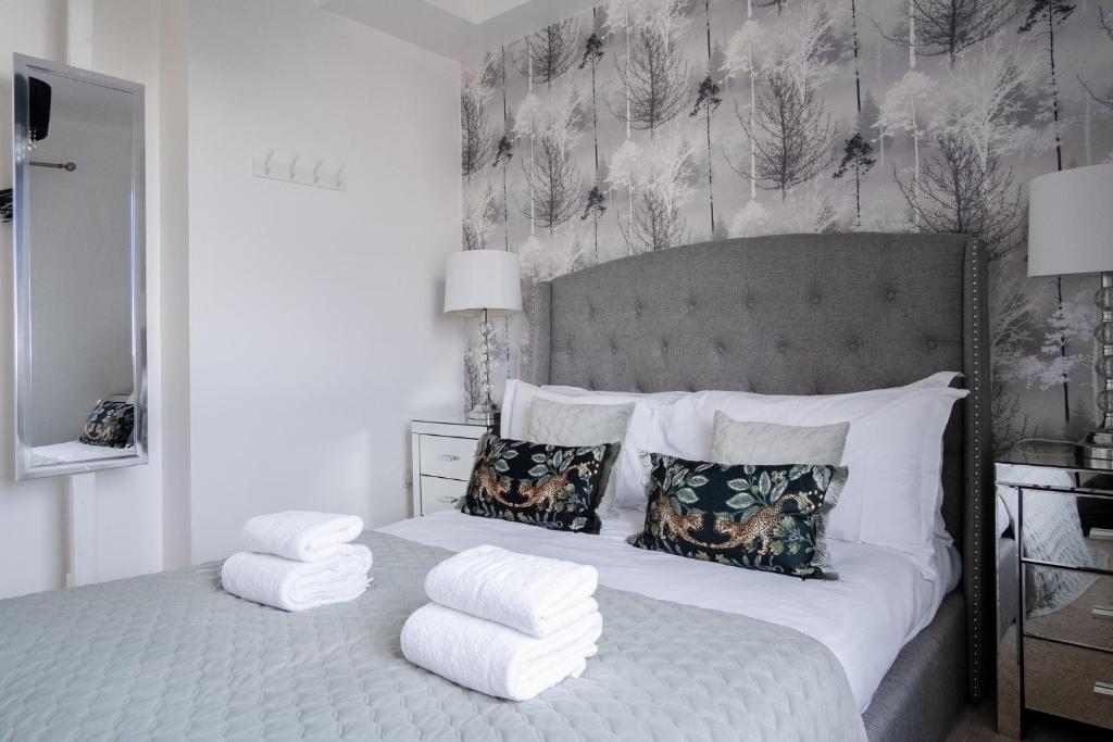 a bedroom with a bed with white sheets and pillows at Luxury one bed Apartment in Carterton
