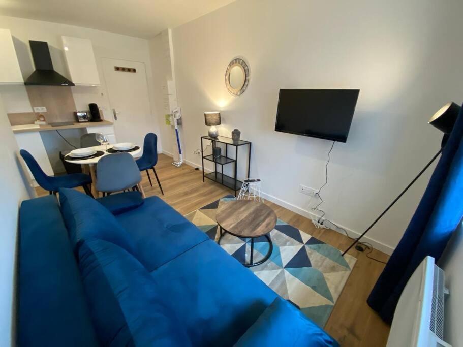sala de estar con sofá azul y TV en T2 Chic - Blue & Grey, en Mazamet