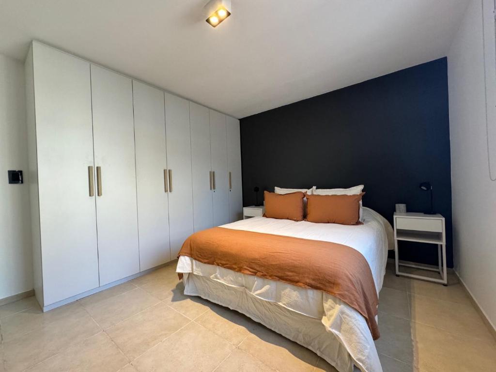 ein Schlafzimmer mit einem großen Bett und einer blauen Wand in der Unterkunft Departamento VIGGO in Mendoza