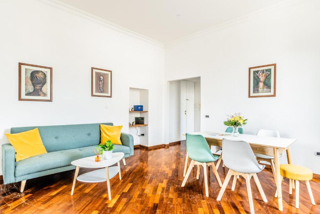 un soggiorno con divano blu e sedie di Bacoli Sveva Luxury House - Terrace & Design a Bacoli