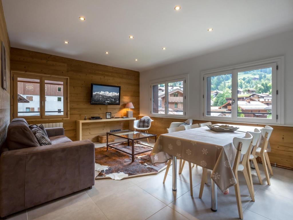 un salon avec une table et un canapé dans l'établissement Chalet cosy au cœur du village, proche pistes et activités, avec cheminée et WIFI - FR-1-304-6, à La Clusaz