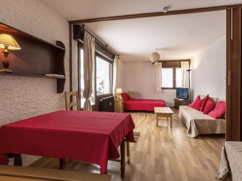 sala de estar con mesa roja y sofá en Appartement La Clusaz, 2 pièces, 4 personnes - FR-1-304-4, en La Clusaz