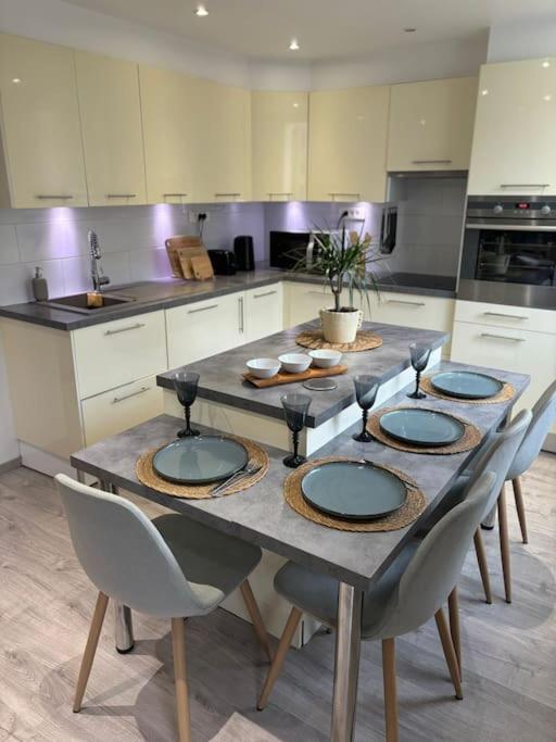 une cuisine avec une table et 4 assiettes. dans l'établissement Your Apartment at Riviera Bliss, à Antibes