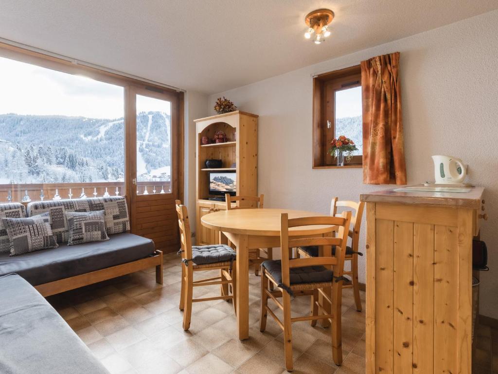 a dining room with a table and a view of a mountain at Appartement La Clusaz, 2 pièces, 5 personnes - FR-1-304-33 in La Clusaz