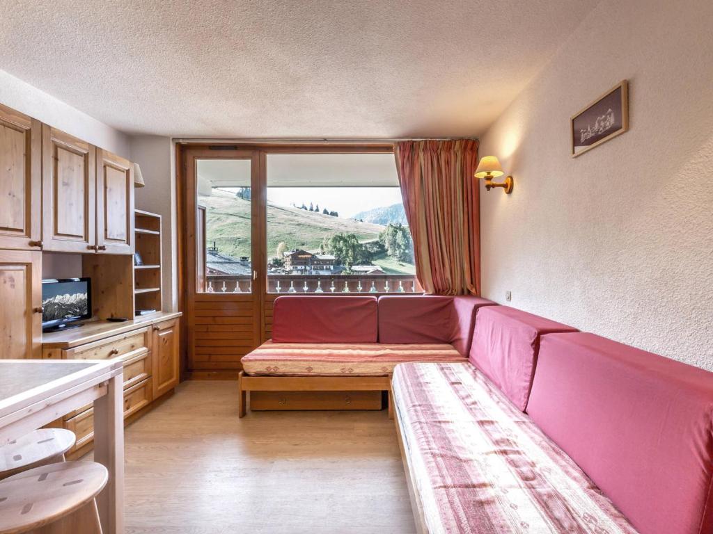 a living room with a red couch and a window at Studio La Clusaz, 1 pièce, 4 personnes - FR-1-304-30 in La Clusaz