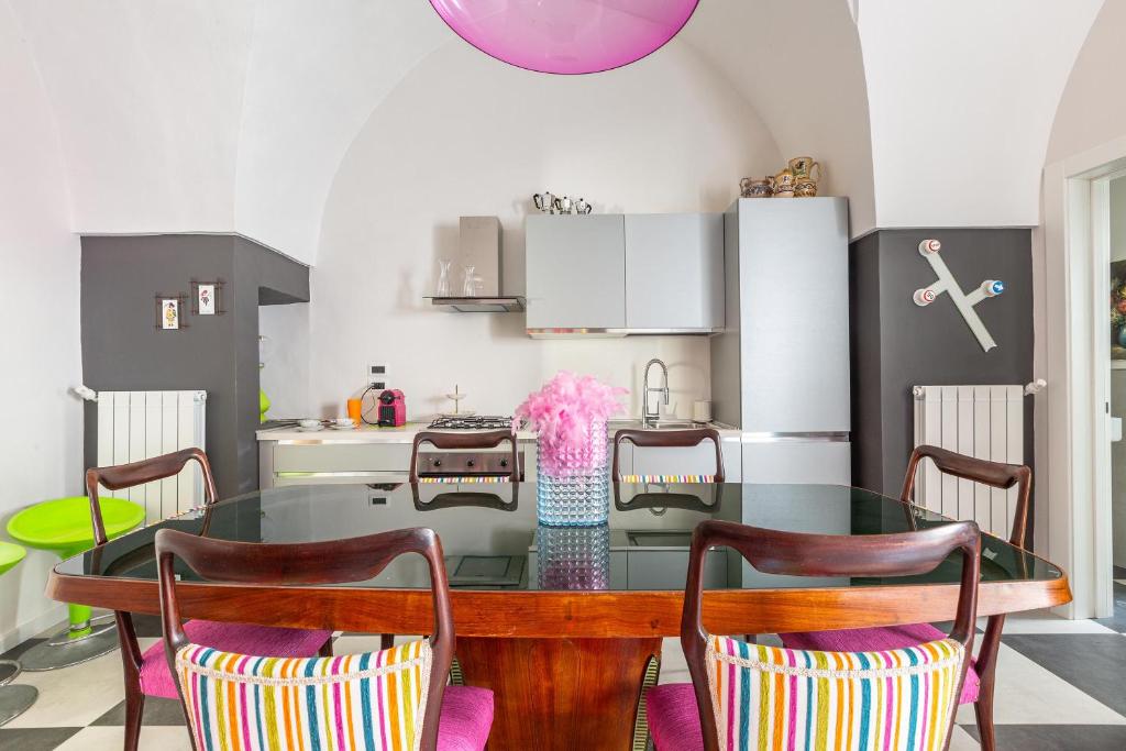 uma sala de jantar com uma mesa de vidro e cadeiras em Carraio Salentino by BarbarHouse em Parabita