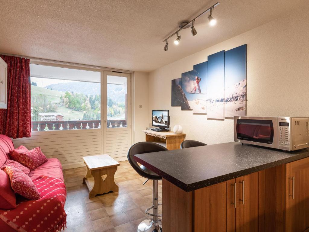 a living room with a couch and a microwave at Studio La Clusaz, 1 pièce, 3 personnes - FR-1-304-264 in La Clusaz