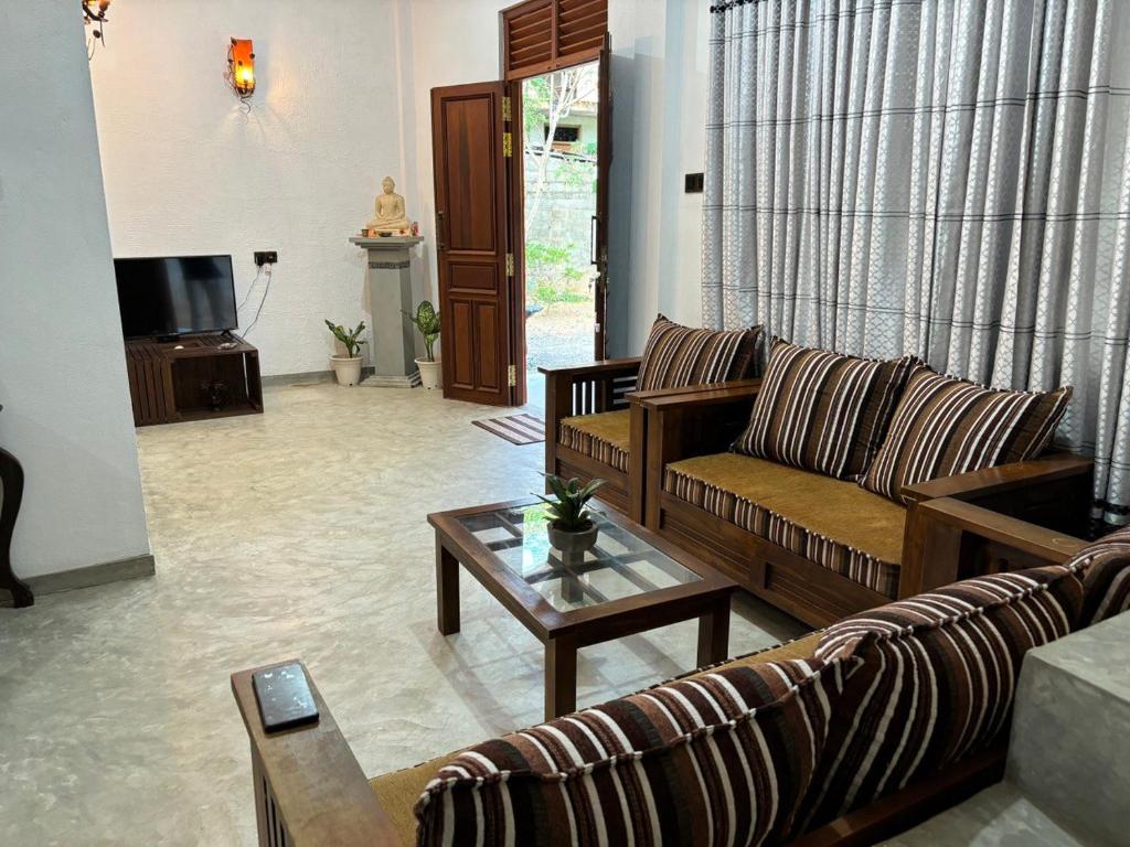 a living room with a couch and a coffee table at Water Angel Villa in Kamburugamuwa