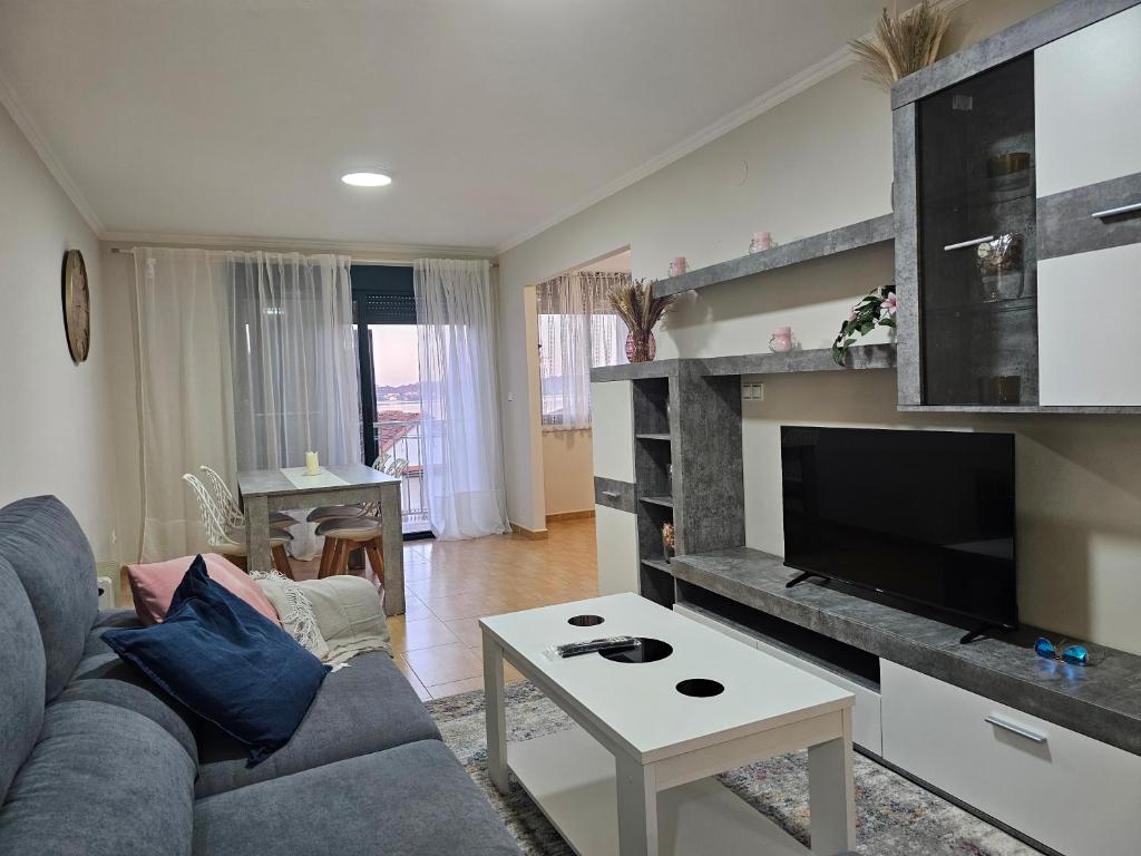 - un salon avec un canapé et une télévision dans l'établissement Apartamento Nara Playa, à Boiro
