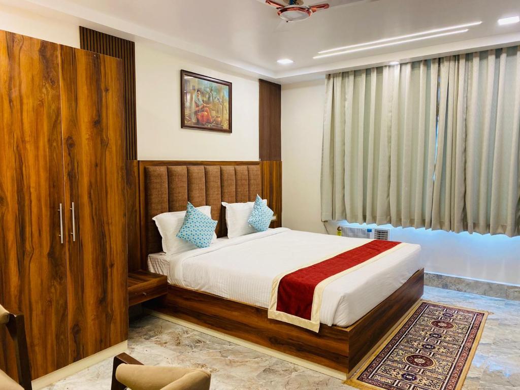 a bedroom with a bed and a large window at HOTEL MAA LAXMI PALACE in Deoghar